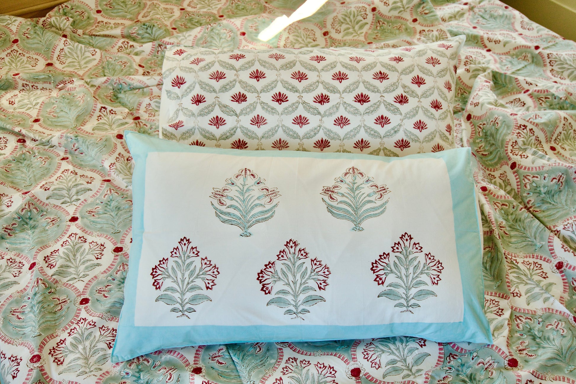 Decorative pillows with floral patterns on a matching fabric background