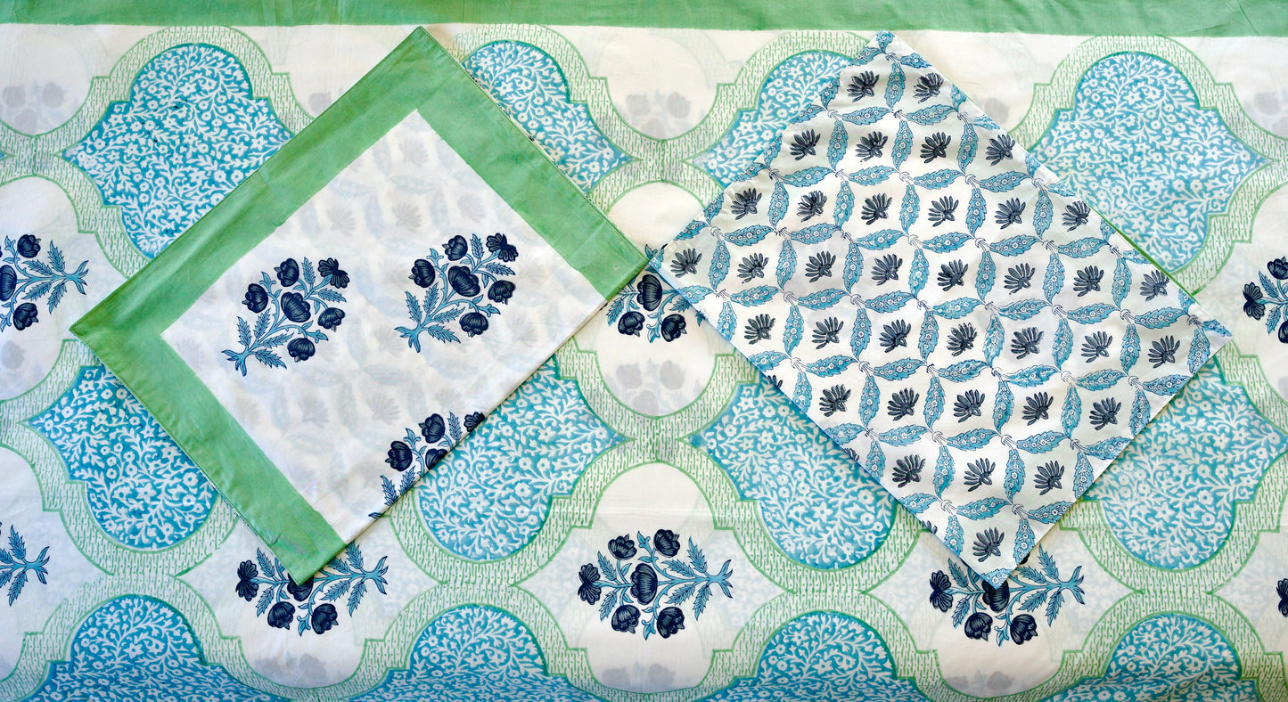 zure Lattice hand block printed organic cotton bedsheet with navy floral clusters, teal-green leaves, white base, aqua lattice panels, and matching floral patterned pillowcases
