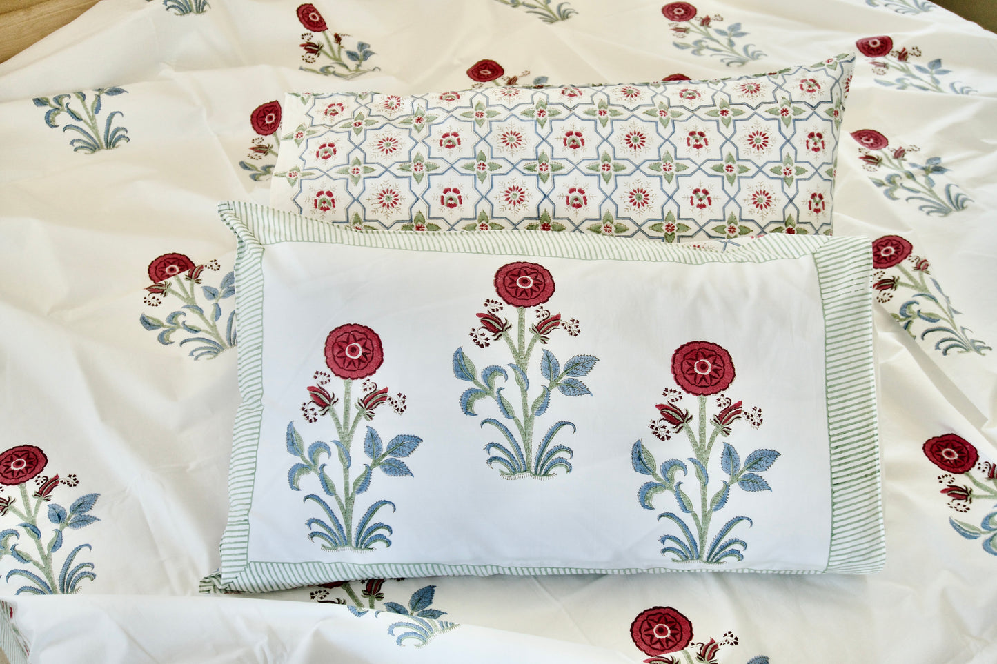 Embroidered floral designs on fabric with a focus on red and green colors.