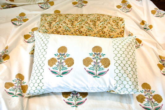 Golden_Marigold Hand block printed organic cotton bedsheet with golden-yellow floral motifs, green lattice detailing, pink accents, and matching pillowcases with yellow floral repeat patterns
