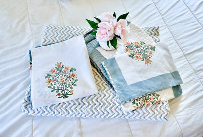 Ornate Bouquet 6-piece hand block printed organic cotton set with floral bouquet motifs, green leaves, white base, blue borders, zig-zag quilt, and matching pillowcases