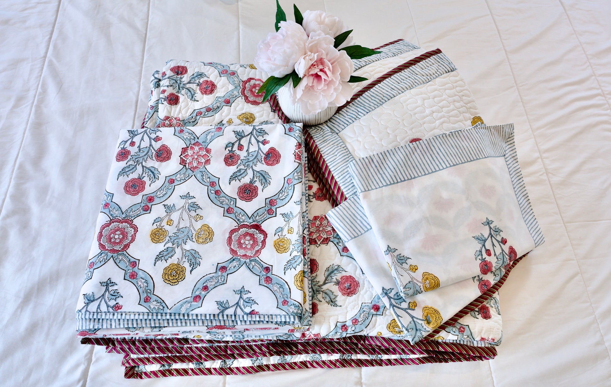 Regal Medallion 6-piece hand block printed organic cotton bedsheet and quilt set with red and yellow floral medallions, green leaves, blue arches, striped borders, and quilted pillowcases.