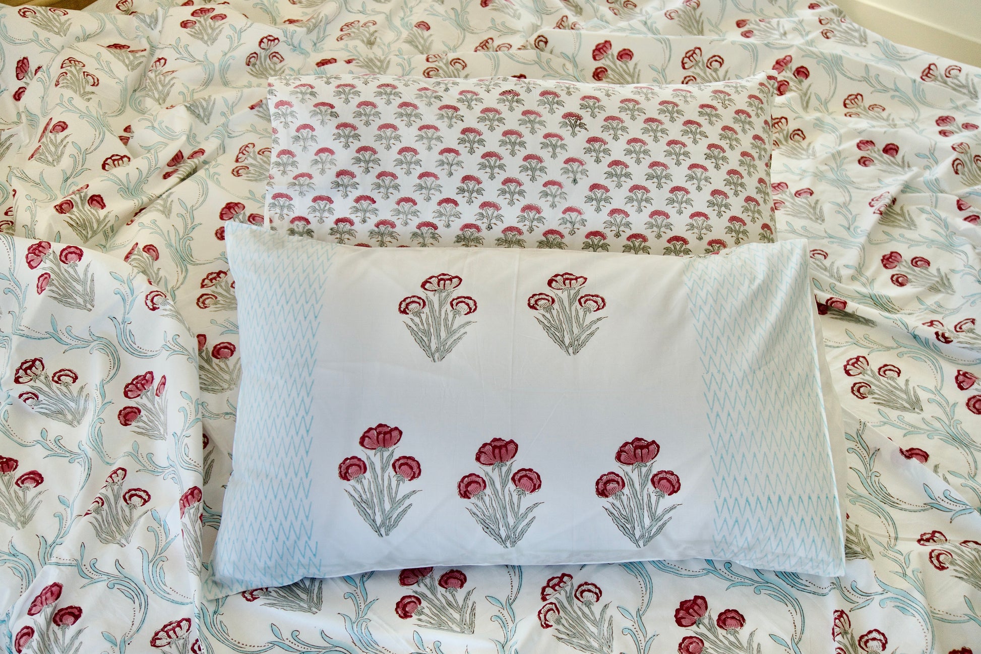 Floral patterned pillow and bedspread on a bed