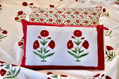Rosewood Royale hand block printed organic cotton bedsheet with bold red floral motifs, green leaves, white base, and red border pillowcases.