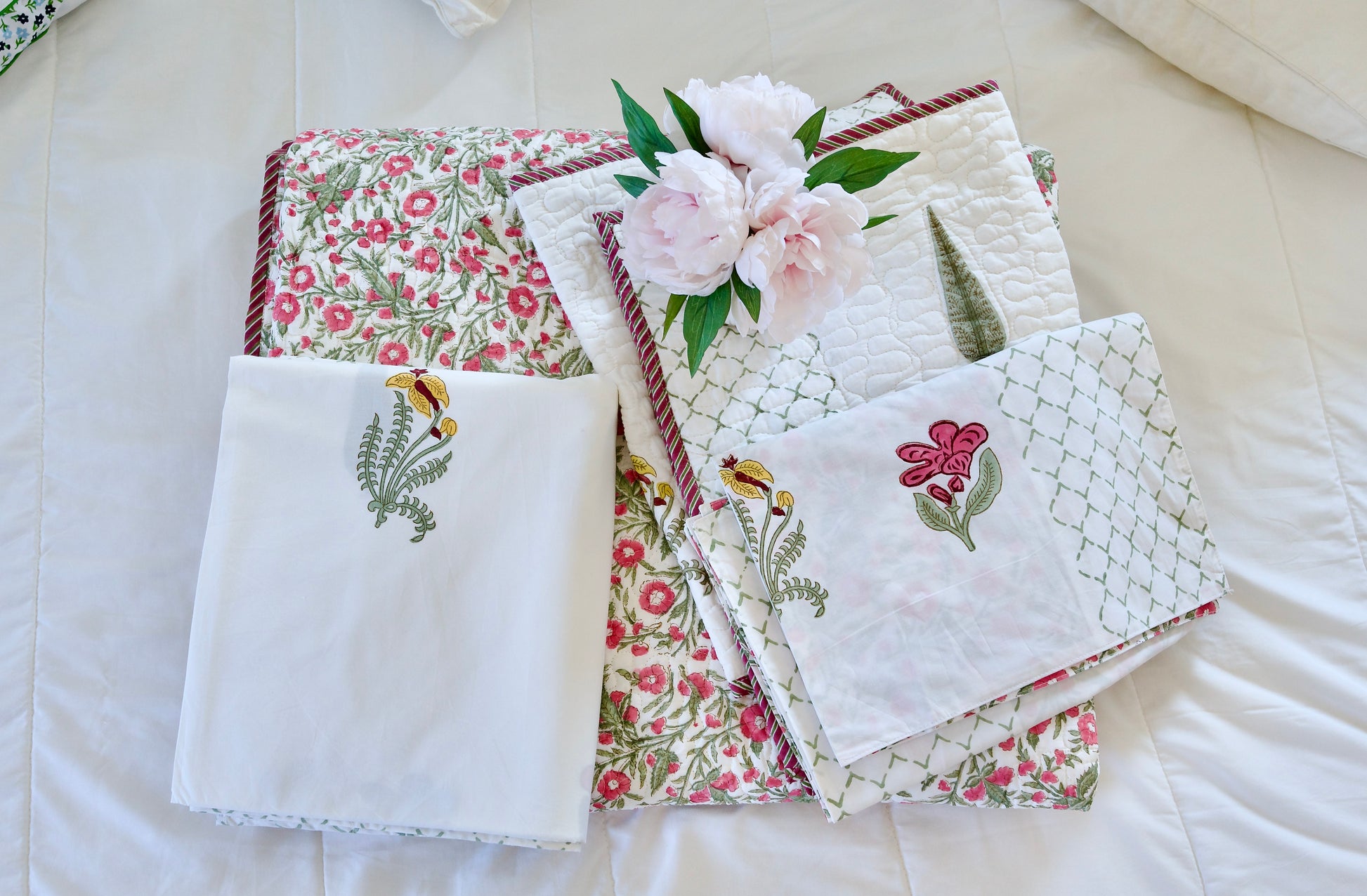 Spring Medallion 6-piece hand block printed organic cotton bedsheet and quilt set with pink florals, green leaves, yellow details, white base, and lattice-style patterned pillowcases